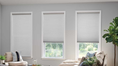 three light grey cellular or honeycomb shade in a sitting room
